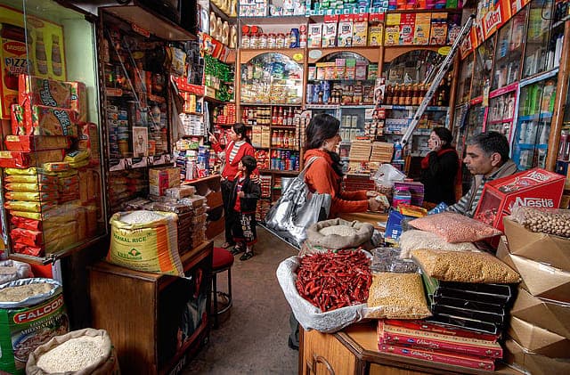 An interior shot of a brightly lit, well-stocked Indian Kirana store, creating a welcoming atmosphere.